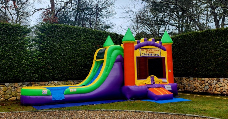 Orange, yellow and purple bounce house with slide